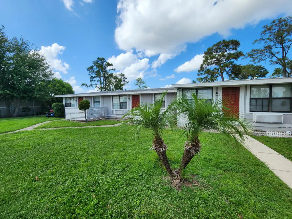 Single-story apartment homes with palm trees at Heatherwood Apartments
