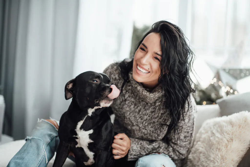 Resident relaxing with her dog in a pet-friendly apartment
